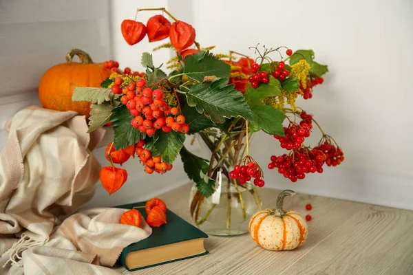 Beautiful autumn composition with different pumpkins and book indoors