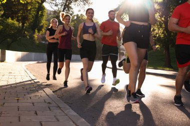 Güneşli bir günde dışarıda koşan bir grup insan.