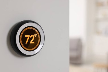 Termostat Fahrenheit ölçeğinde sıcaklık gösteriyor. Beyaz duvarda akıllı ev aygıtı, metin için boşluk
