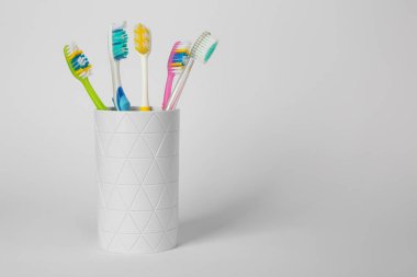 Açık gri arka planda farklı diş fırçaları var. Metin için boşluk