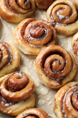 Parşömen kağıdının üstünde kremalı tarçınlı börekler.