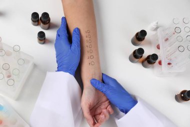 Doktor ışık masasında cilt alerjisi testi yapıyor.
