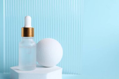 Açık mavi arkaplanda kozmetik serumunun şık sunumu, metin için boşluk