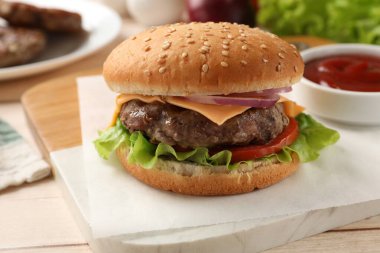 Köfteli lezzetli hamburger, peynir ve sebzeler ışık masasında, yakın plan