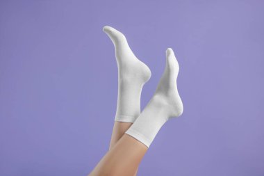 Mor arka planda şık beyaz çoraplı kadın, yakın plan.