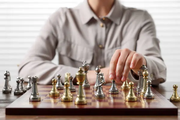 Woman playing chess during tournament at table, closeup