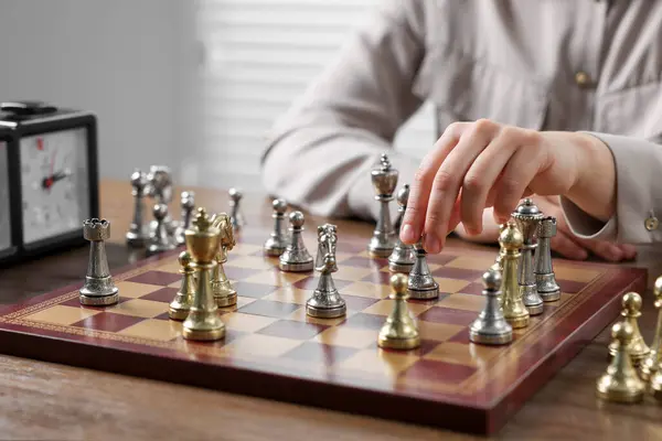Woman playing chess during tournament at table, closeup