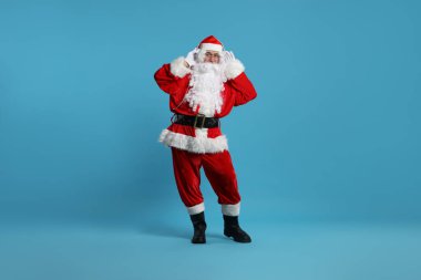 Mutlu noeller. Kulaklıklı Noel Baba açık mavi arka planda müzik dinliyor.