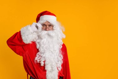 Mutlu noeller. Noel Baba turuncu arka planda göz kırpıyor, mesaj için boşluk