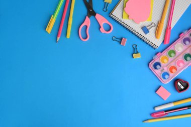 Açık mavi arkaplan üzerine dizüstü bilgisayar ve diğer okul kırtasiyesiyle düz kompozisyon, metin için boşluk. Okula geri dön.