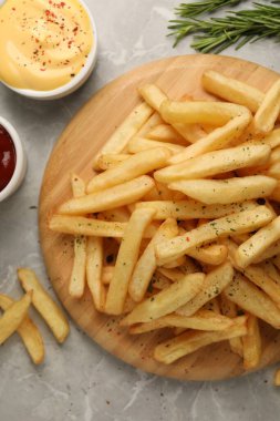 Lezzetli patates kızartması. Gri mermer masada sosla servis ediliyor.