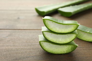 Ahşap masada taze aloe vera parçaları, yakın plan. Metin için boşluk