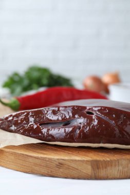 Beyaz ahşap masada çiğ sığır ciğeri, yakın plan. Metin için boşluk