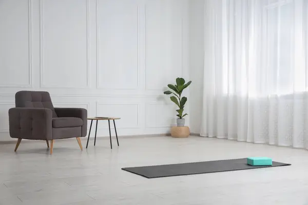 Exercise mat and yoga block indoors. Space for text