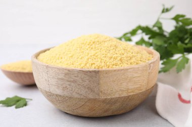 Masadaki ahşap kasede çiğ kuskus, yakın plan.