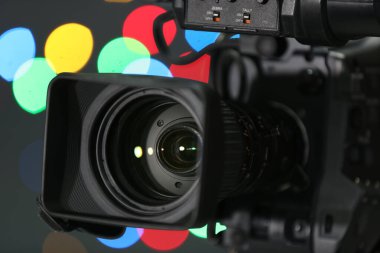 Bulanık renkli ışıklara karşı modern video kamera, yakın plan