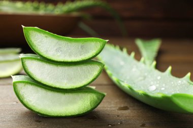 Taze aloe vera parçaları ahşap masada, yakın plan.
