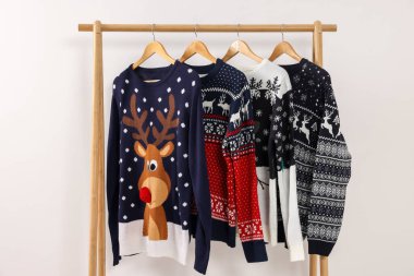 Beyaz arka planda farklı Noel süveterleriyle rafa kaldır