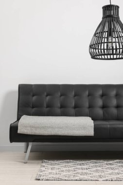 Oturma odasında gri battaniyeli rahat bir kanepe