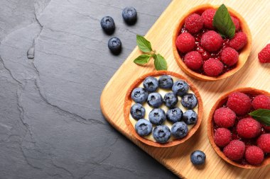 Farklı taze böğürtlenli börekler siyah masada, düz yerde ve metin için yer var. Tatlı nefis.