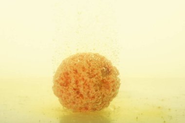 Beyaz arka planda suda sarı banyo bombası