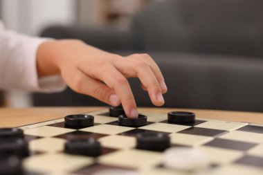 Çocuk içeride dama oynuyor, yakın plan.