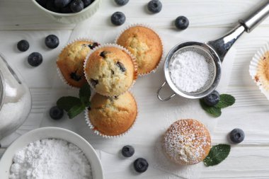 Şeker, yaban mersini ve nane şekerli nefis tatlı kekler beyaz ahşap masa, düz uzanmış