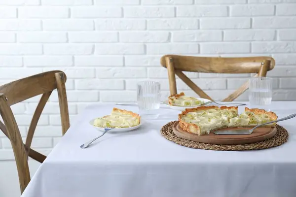 Tasty leek pie and drink served on table