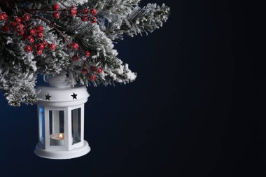 Noel feneri, köknar ağacında yanan mum ile karanlık arka planda, yakın plan. Metin için boşluk