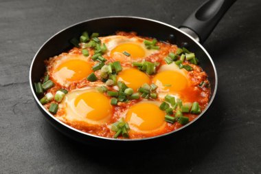 Lezzetli Shakshuka siyah desenli masada kızartma tavasında, yakın plan.