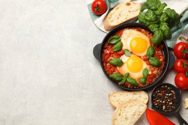 Lezzetli Shakshuka açık gri masada servis edilir, düz yatar. Metin için boşluk