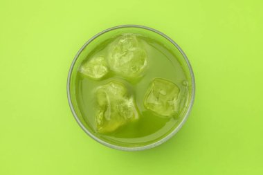 Yeşil arka planda bir bardak lezzetli buzlu kibrit çayı.