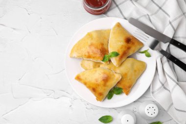 Beyaz desenli masada servis edilen leziz samosalar. Metin için boşluk