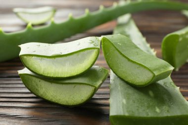 Taze aloe vera parçaları ahşap masada, yakın plan.