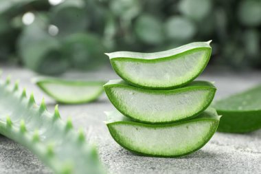 Gri masada taze aloe vera parçaları, yakın plan.