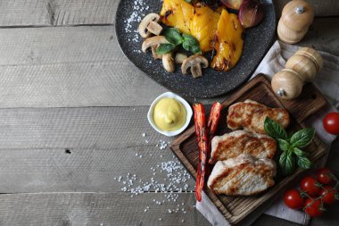 Ahşap masada servis edilen nefis ızgara et ve sebzeler. Metin için boşluk