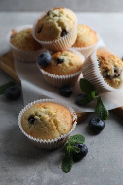 Yaban mersinli lezzetli çörekler ve gri masada nane şekeri.