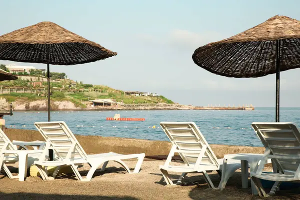 Lounge chairs and beach umbrellas on sea shore