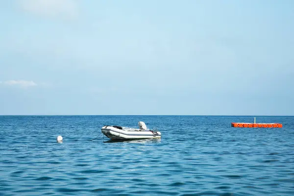 Inflatable boat on sea under blue sky