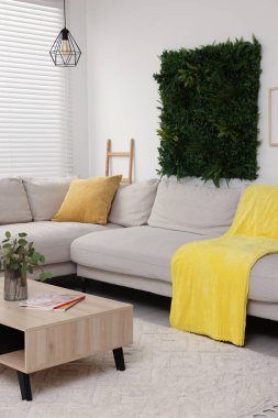 Yeşil yapay bitki paneli ve rahat oturma odasında rahat mobilyalar. İç tasarım