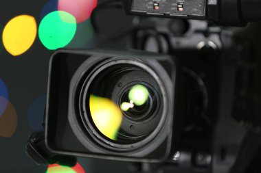 Bulanık renkli ışıklara karşı modern video kamera, yakın plan