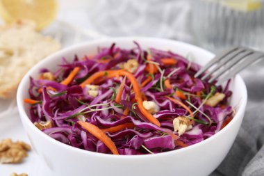 Beyaz masada kırmızı lahana ve ceviz ile lezzetli salata, yakın plan.