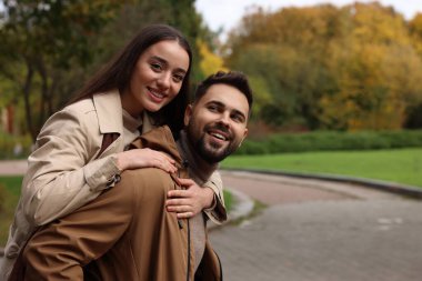 Romantik genç çift, sonbahar parkında birlikte vakit geçiriyorlar.