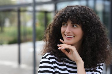 Açık havada güzel bir kadının portresi. Çekici bayan gülümsüyor ve kameraya poz veriyor. Metin için boşluk