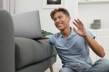 İçerideki bilgisayarla görüntülü konuşma yapan mutlu genç adam.