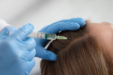 Trikoloğum klinikteki hastaya iğne yapıyor.