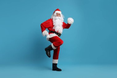 Mutlu noeller. Noel Baba açık mavi arka planda poz veriyor