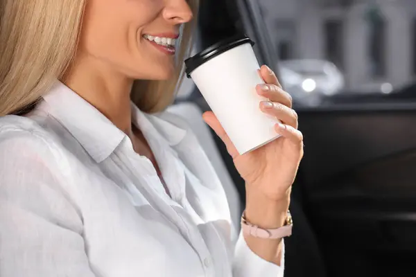 To-go drink. Woman drinking coffee in car, closeup