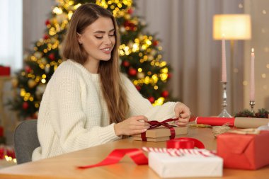 Masada Noel hediyesini süsleyen güzel genç bir kadın.