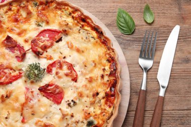 Tahta masada servis edilen domatesli ve peynirli kiş.